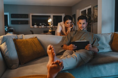 Ein Paar das sich auf dem Sofa informiert