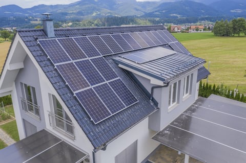 Haus mit Solarpaneelen auf grauem Dach