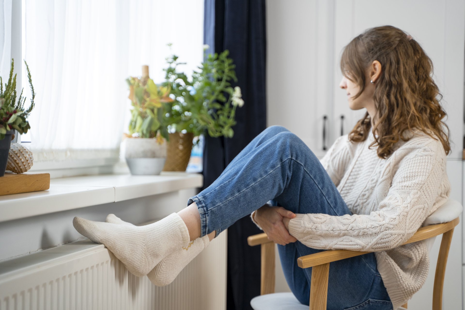 full-shot-woman-sitting-near-heater
